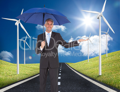 Composite image of peaceful businessman holding blue umbrella