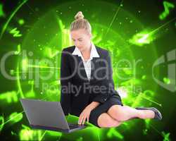 Composite image of businesswoman using laptop