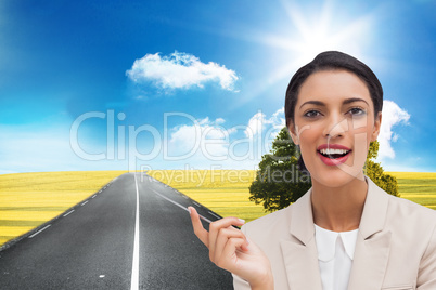 Composite image of smiling businesswoman holding a pen