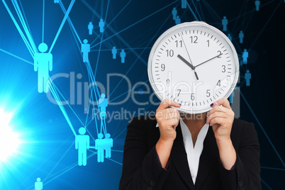 Composite image of businesswoman in suit holding a clock