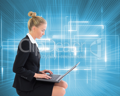 Composite image of businesswoman using laptop