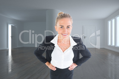 Composite image of businesswoman standing with hands on hips