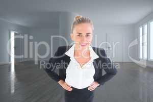 Composite image of businesswoman standing with hands on hips