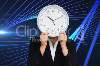 Composite image of businesswoman in suit holding a clock