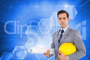 Composite image of serious architect holding plans and hard hat