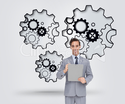 Composite image of happy businessman holding a clipboard