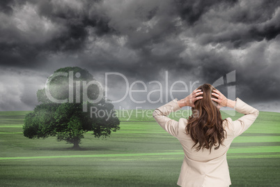 Composite image of businesswoman with hands on head standing bac