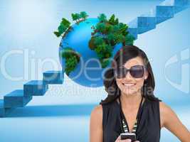 Composite image of happy brunette holding smartphone