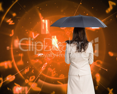 Composite image of rear view of classy businesswoman holding umb