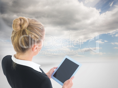 Composite image of businesswoman holding tablet