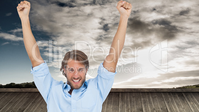 Composite image of happy man celebrating success with arms up