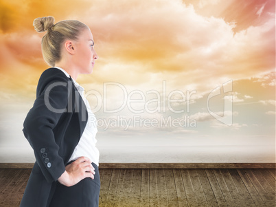 Composite image of businesswoman standing with hands on hips