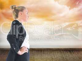 Composite image of businesswoman standing with hands on hips