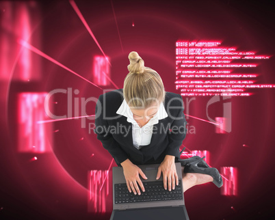 Composite image of businesswoman using laptop