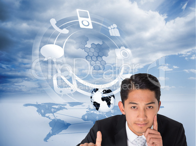 Composite image of thoughtful asian businessman pointing