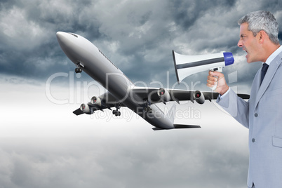 Composite image of businessman shouting in loudspeaker