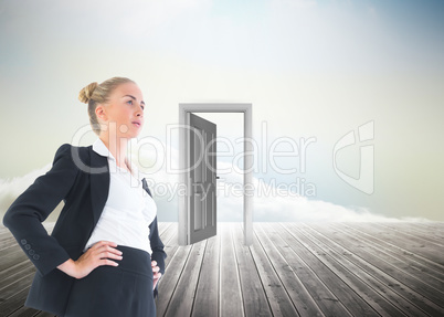 Composite image of businesswoman standing with hands on hips