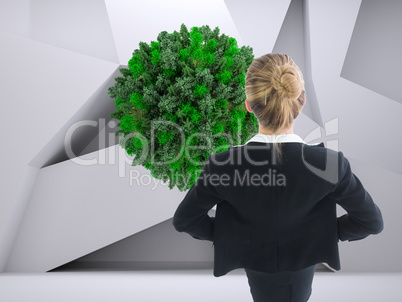 Composite image of businesswoman standing with hands on hips