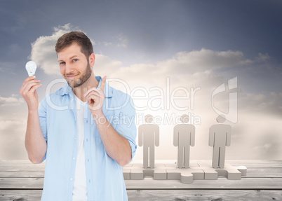 Composite image of charming model holding a bulb in right hand