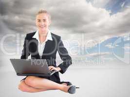 Composite image of businesswoman using laptop