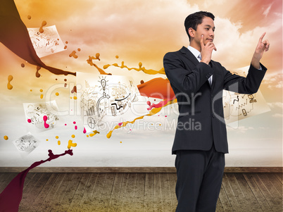 Composite image of thoughtful asian businessman pointing