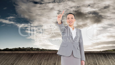 Composite image of smiling asian businesswoman pointing