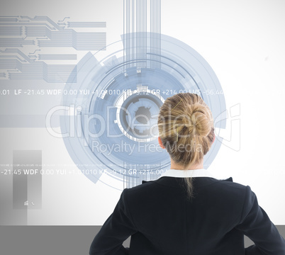 Composite image of businesswoman standing with hands on hips