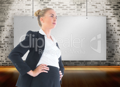 Composite image of businesswoman standing with hands on hips