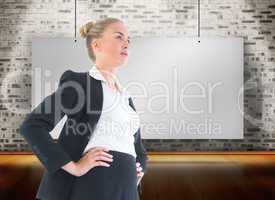 Composite image of businesswoman standing with hands on hips