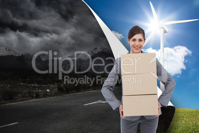 Composite image of smiling businesswoman carrying cardboard boxe