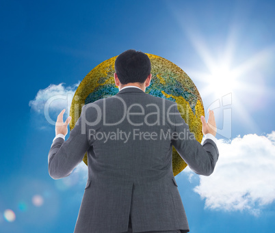 Composite image of businessman with arms raised