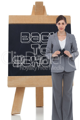 Composite image of young businesswoman with binoculars