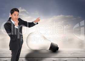 Composite image of thoughtful asian businessman pointing