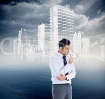 Composite image of thinking businessman holding glasses