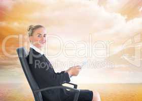 Composite image of businesswoman sitting in swivel chair holding