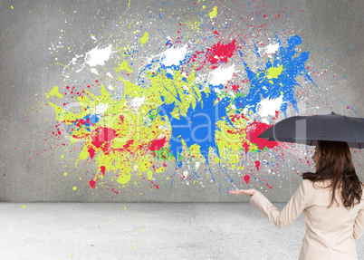 Composite image of elegant businesswoman holding black umbrella