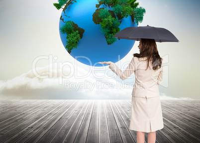 Composite image of elegant businesswoman holding black umbrella