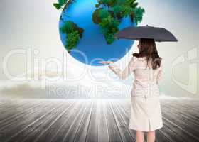 Composite image of elegant businesswoman holding black umbrella
