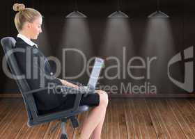 Composite image of businesswoman sitting on swivel chair with la