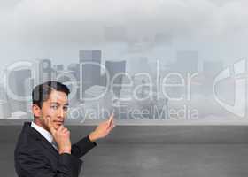 Composite image of thoughtful asian businessman pointing