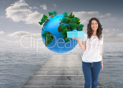 Composite image of content casual brunette holding a present