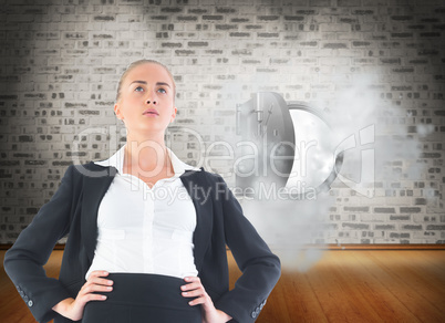 Composite image of businesswoman standing with hands on hips