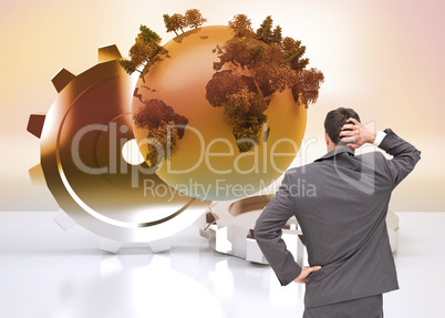 Composite image of young businessman standing back to camera scr