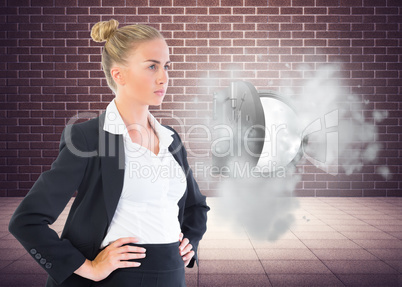 Composite image of businesswoman standing with hands on hips