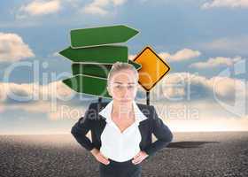 Composite image of businesswoman standing with hands on hips