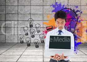 Composite image of businessman showing a laptop