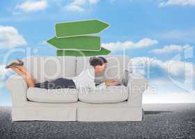 Composite image of business woman lying on couch