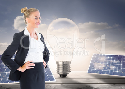 Composite image of businesswoman standing with hands on hips