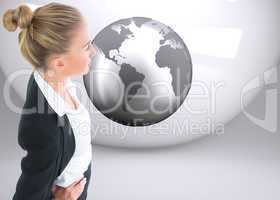 Composite image of businesswoman standing with hands on hips