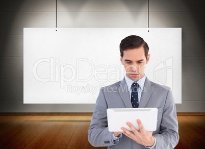 Composite image of businessman holding a tablet computer